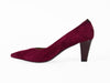 deep red mid-height heeled shoe with glossy patent leather on one side and rich suede on the other, overlapping on the front of the shoe