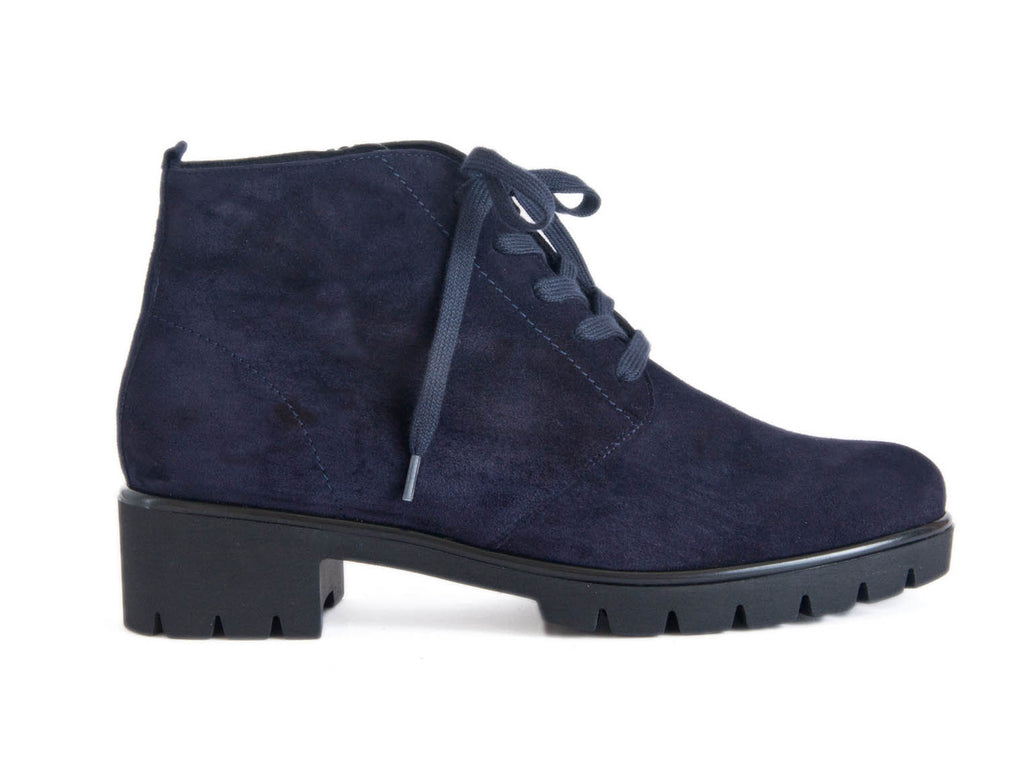 Side view of navy blue suede ankle boots with black chunky grippy sole and heel