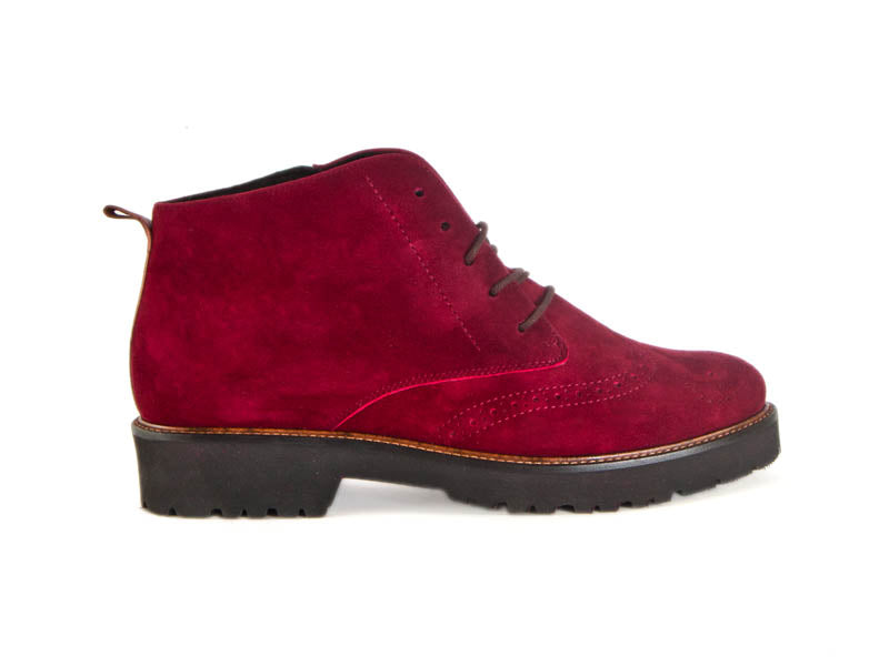 Side view of ladies wine red suede brogue style ladies ankle boots with flat black heel and sole and skinny laces