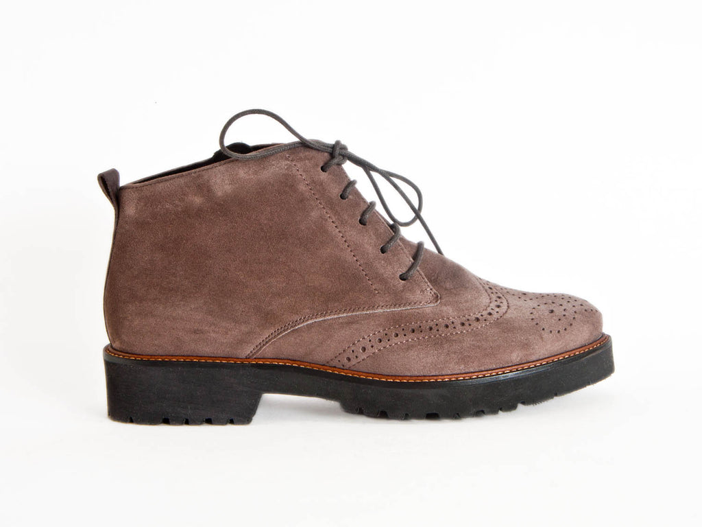 Side view of grey brown suede brogue style ladies ankle boots with flat black heel and sole and skinny laces