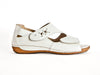 white leather summer shoes with adjustable velcro straps and decorative detail on the top strap