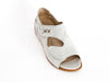 white leather summer shoes with two curved straps over the top of the foot and decorative detail on top strap
