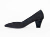 black grey mid-height heeled shoe with glossy patent leather on one side and rich suede on the other, overlapping on the front of the shoe